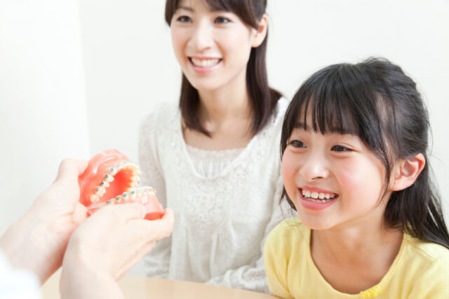 小児矯正の説明を受ける適齢期の子ども