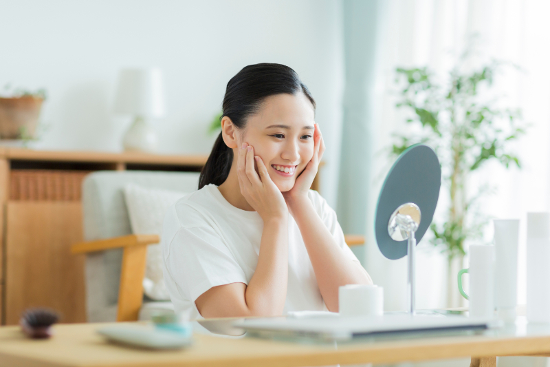 マウスピース矯正で綺麗になった歯並びを見て嬉しそうな女性