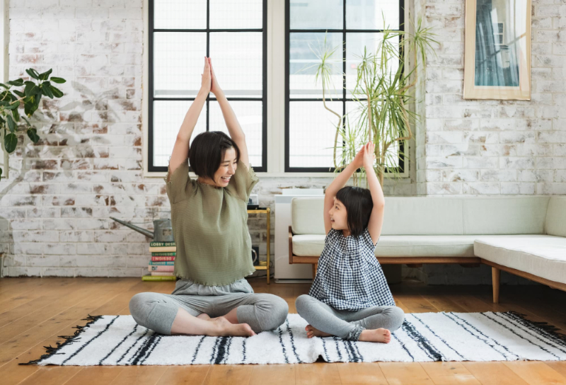 微笑み合いながらヨガをする親子