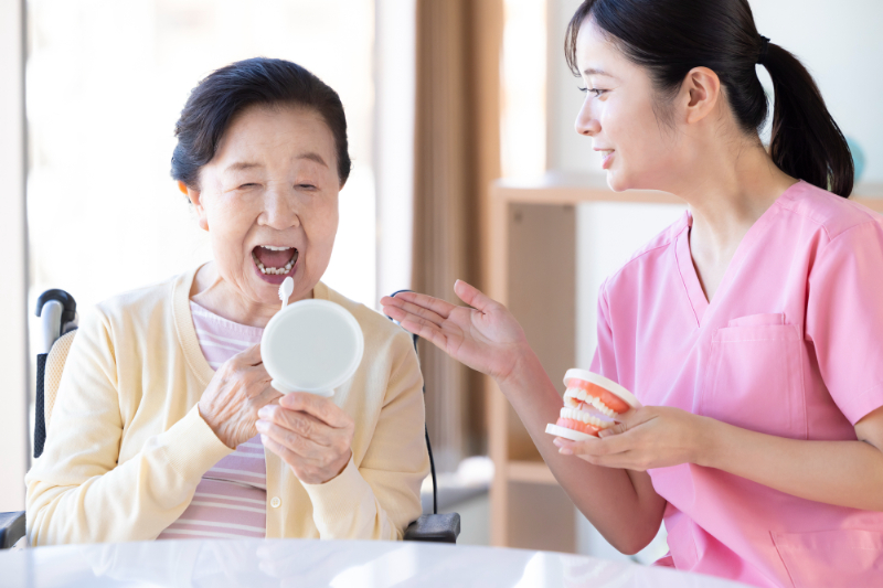 高齢女性と歯科衛生士が口腔ケアを行う様子