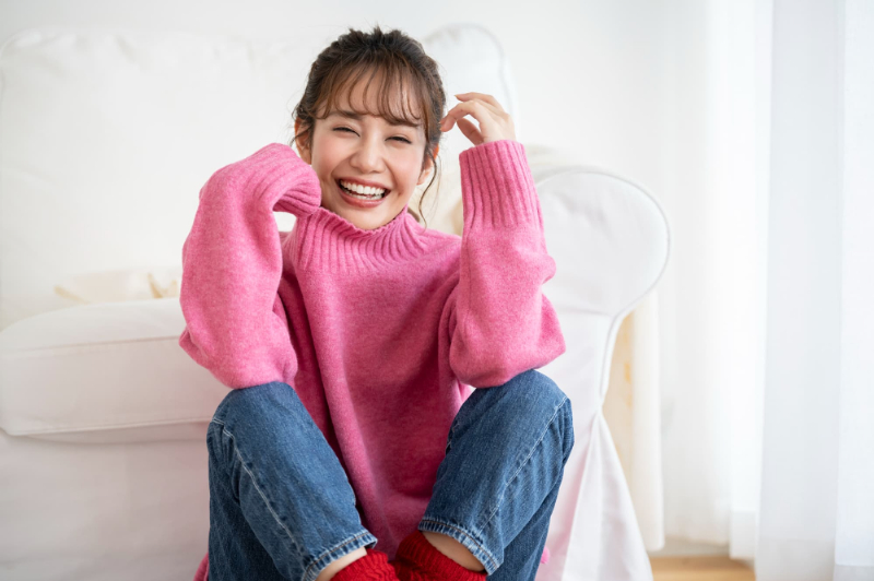 ピンクのニットを着た笑顔の女性
