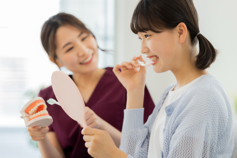 歯科医院で歯磨き指導を受ける女性