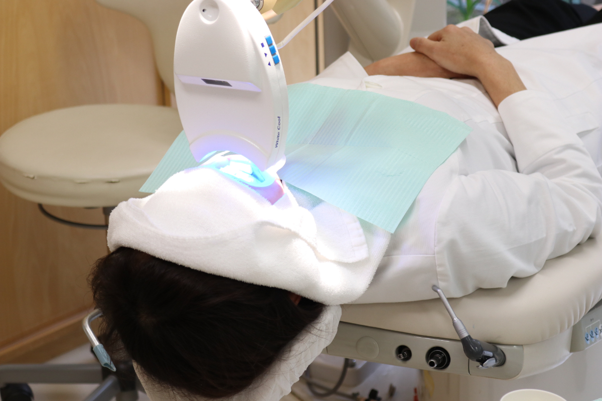 審美歯科で前歯を美しくするためにホワイトニング治療を受けている人