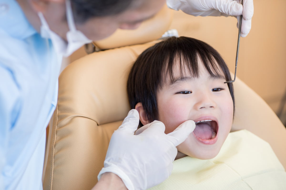 歯科医院で矯正後の診察を受ける男の子