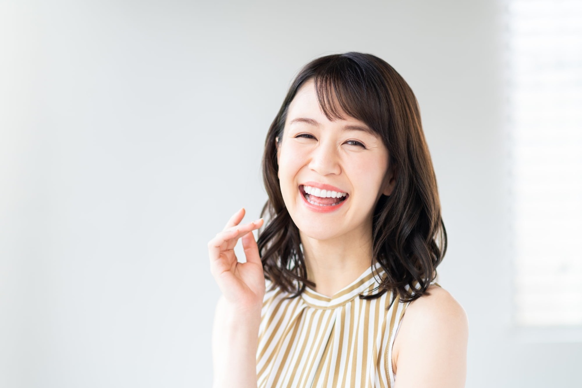 出っ歯の矯正治療に満足して笑う女性