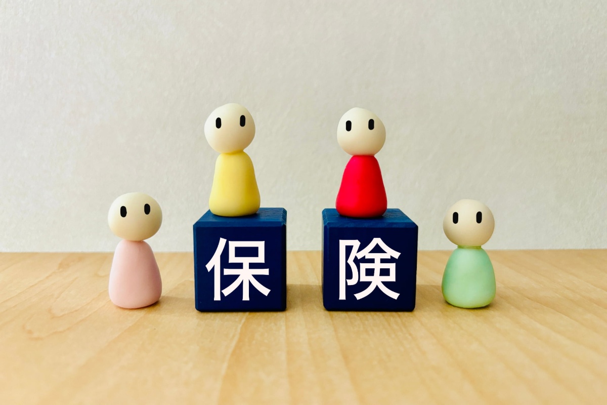 保険と書かれた紺色のブロックと人形達