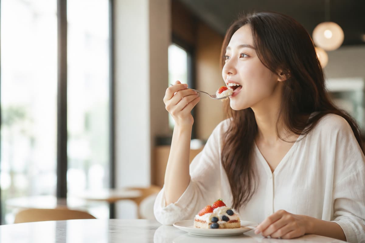 顎の痛みが改善してカフェで食事を楽しむ女性